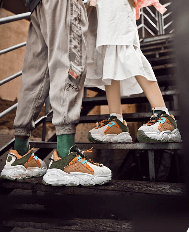 Two people wearing Waterproof Thick Bottom Running Shoes SF0376, featuring a sturdy design and vibrant colors on outdoor stairs.